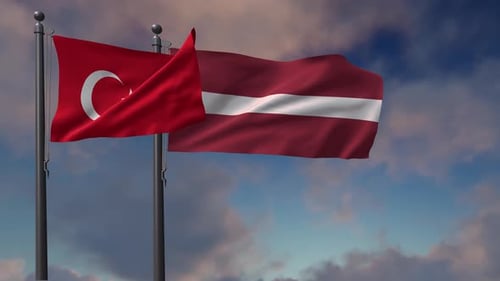 Flags of Turkey and Latvia Waving Against a Cloudy Sky