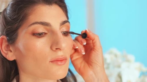 Glamorous Woman Having Mascara Applied in Bright Light