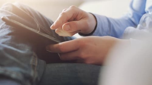 Hands Scrolling on Tablet Device at Home
