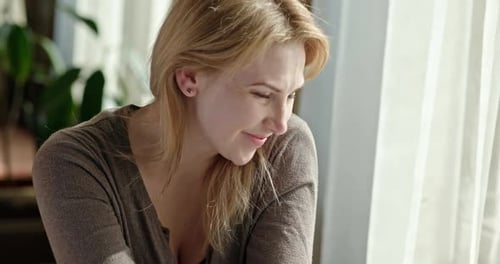 Blonde Woman Smiling by Window