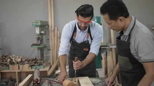 Carpenters are working together at workshop.