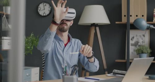 Office Worker Wearing Virtual Reality Glasses Relaxing at Work During Break Using Modern Equipment