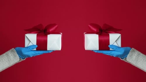 Hands in Gloves Holding Holiday Gifts