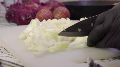 Person Chopping White Onions With Knife on Board