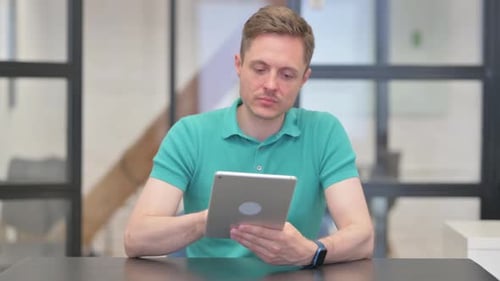 Young Adult Using Tablet in Workplace Setting