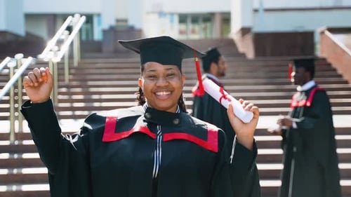 African American Female Student Celebrating Graduation Near College