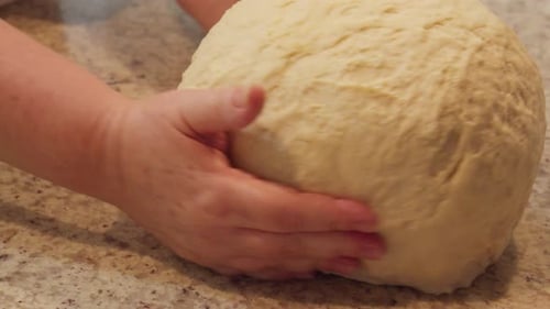 Baker turning a big ball of dough in slow motion