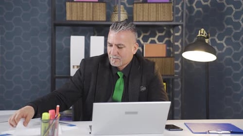 Mature Man Working at Desk with Laptop