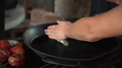 Frying tortillas in an iron skillet on an old coal stove the traditional way