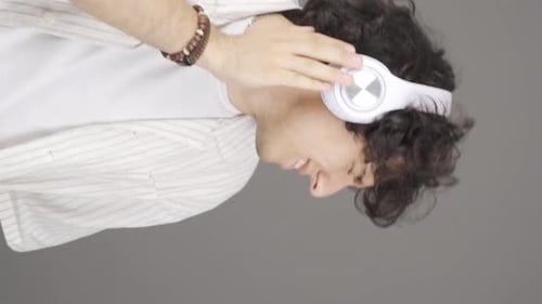 Vertical video of Happy young man listening to music.