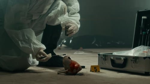 Crime Scene Investigators Examining Evidence in Dark Room