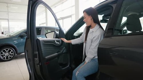 Female Client Customer Choosing New Car and Checks It Before Purchasing