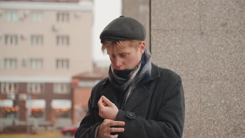 Vibrant Young Person Arranges Clothing Near Building in City Creative Individual in Layered Clothing
