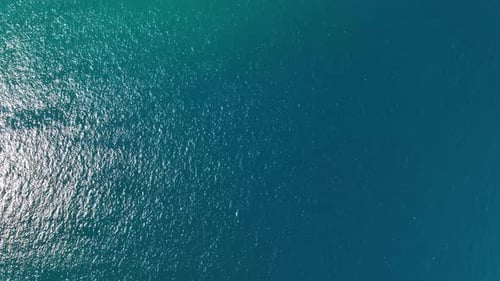 An aerial view of the sail yacht on the blue sea. Transparent clear water in the sea.