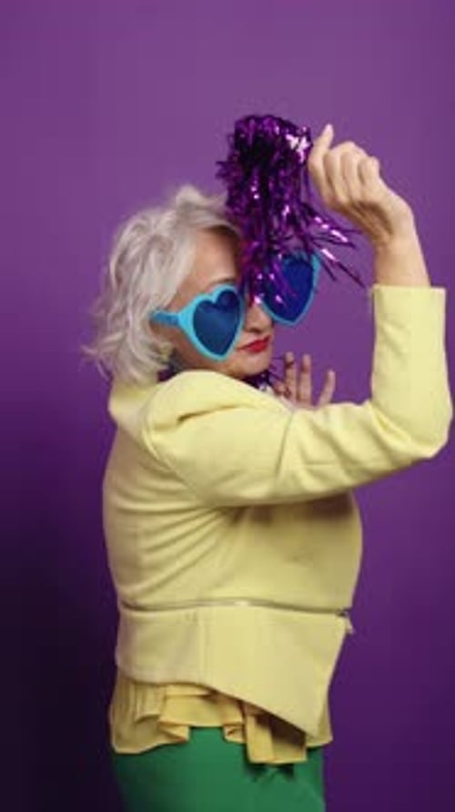 Senior Woman Celebrates with Pom Poms and Sunglasses