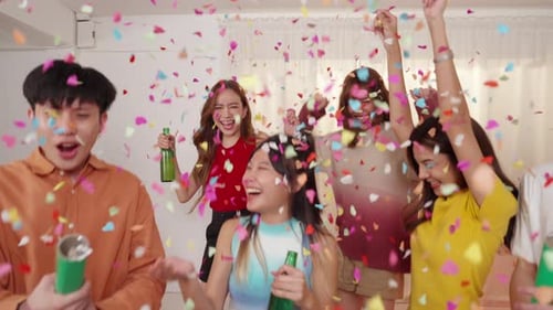 Group of Young Asian people celebration holiday party and playing confetti together in living room.