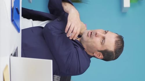 Man in Pain Rubbing his Neck at Work