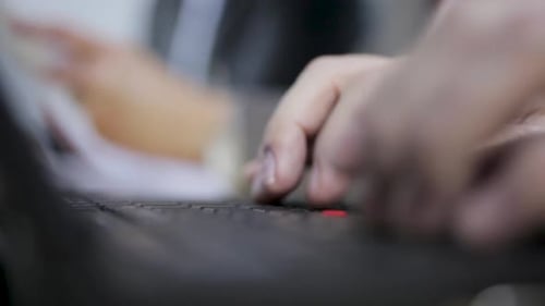 Nahaufnahme von Händen, die schnell auf einer Laptoptastatur tippen, Fokus auf Finger und Tasten