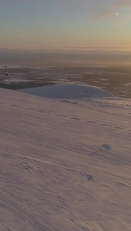 Les gens font du ski et du snowboard sur une piste de ski avec un téléphérique au coucher du soleil Vidéo verticale