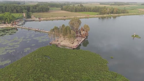 Aerial View Of A Lake With A Bridge Island And Surrounding Greenery