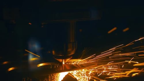 Slow Motion. Close up detail shot of precision laser cutting through metal with sparks.