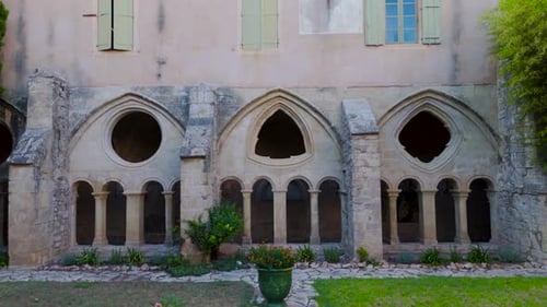 Slow establishing shot of a geometric archway in a french abbeys courtyard