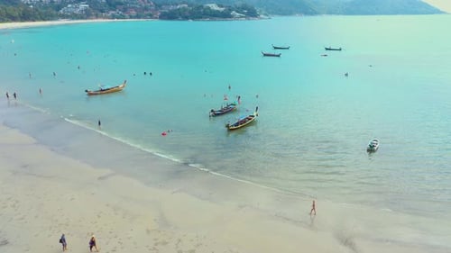 Aerial view or top view of long-tailed boat is floating on the emerald sea. Calm andaman sea at Phuk