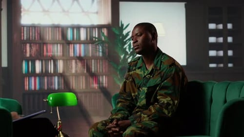 Man Talking in Military Uniform on Green Sofa