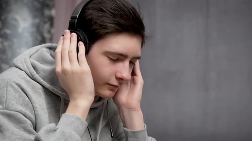 Teen Listening to Music with Headphones Indoors