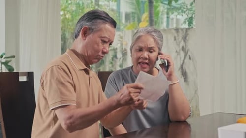 Concerned Senior Woman Talking on Phone with Man