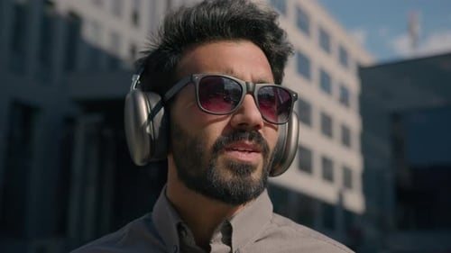 Man Smiling With Headphones and Sunglasses in City