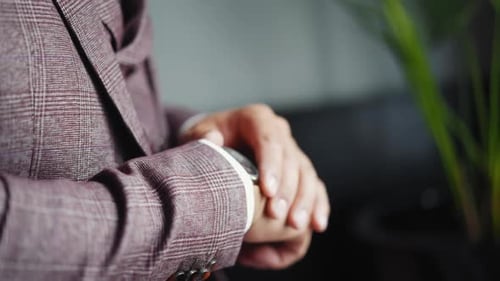 Man In Suit Clasping Hands Wearing Watch