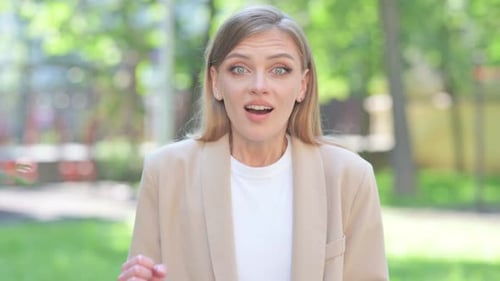 Woman Celebrating Good News in a Green Setting