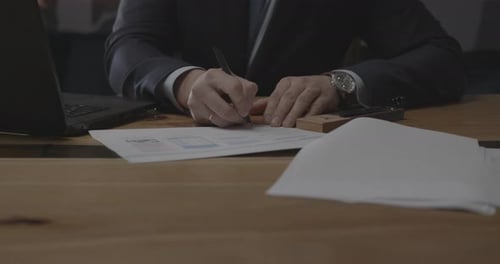 Man Signs Documents in Office Setting