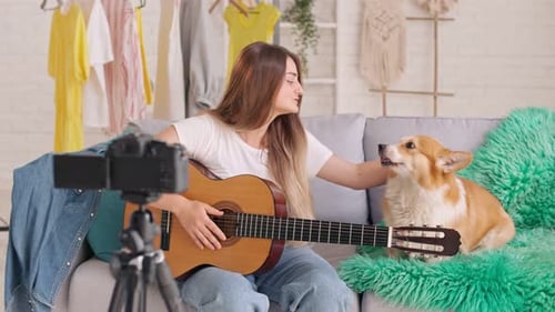Woman Plays Guitar and Sings with her Dog