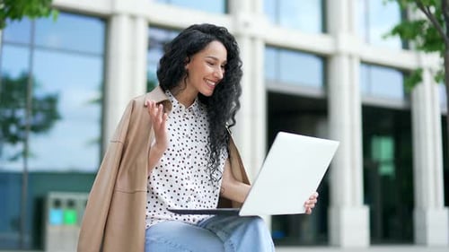Young Woman Video Calling Outdoors on Laptop