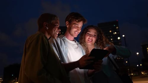 Diverse Friends Using a Tablet at Night in the City
