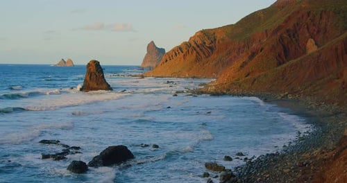 Large waves with foam roll on hilly ocean rocky beach at sunset. Relax 4k enjoy the landscape view.