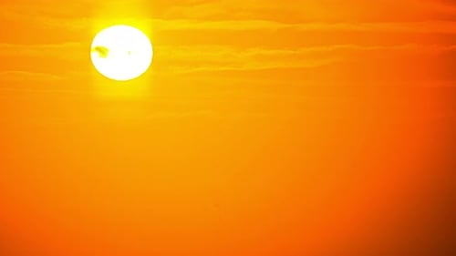 Golden Sunset Descending Among Orange Sky and Clouds