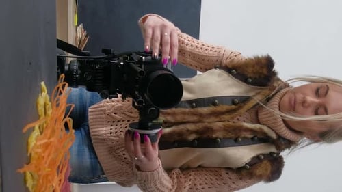 Woman Adjusting Professional Film Camera Indoors