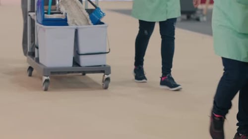 Chariot de conciergerie avec serpillères et produits de nettoyage dans le couloir de l'établissement