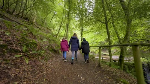 Children Walking With Mother Through Peaceful Forest
