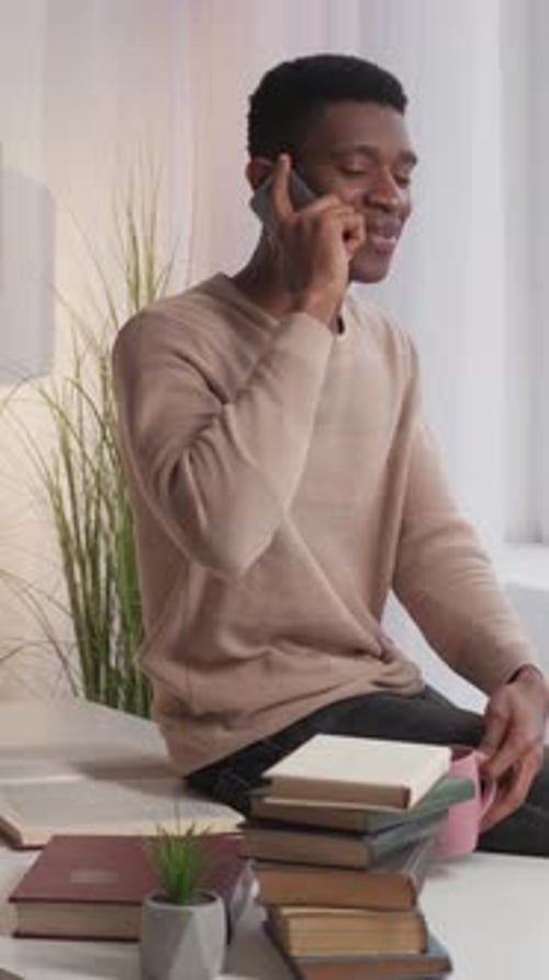 Cheerful Young Adult Chatting on Phone at Home