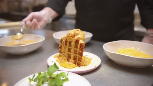 Chef Pouring Sweet Sauce and Granola on the Piece of Cake