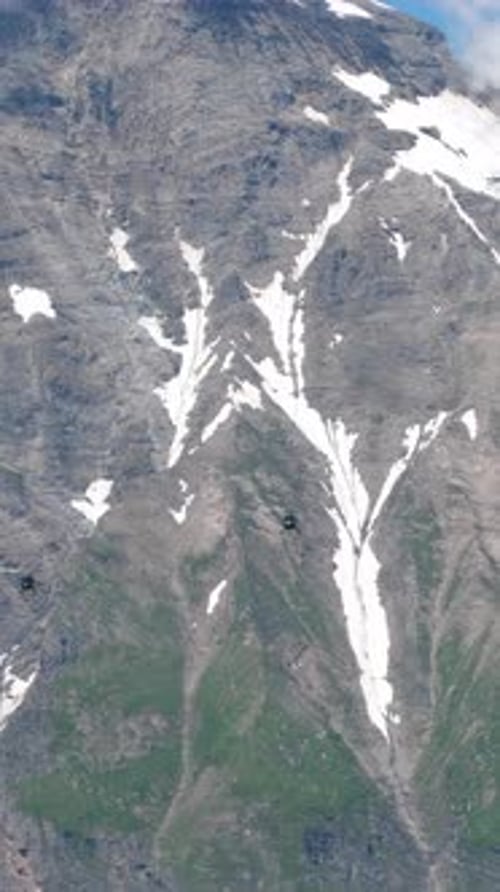 Dos helicópteros cerca de los picos nevados de los Alpes austríacos: zoom 4K