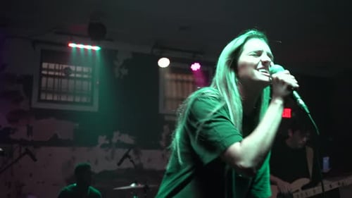 Young Woman Singing on Stage in Music Venue