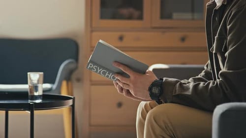 Man Reading Psychology Book at Home on Couch