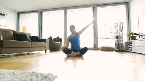 Woman Stretching and Exercising in Bright Living Room