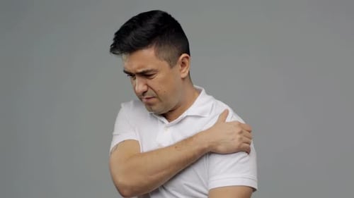 Man in Pain Holding Shoulder
