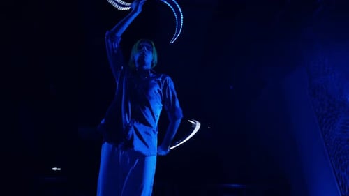 Person Performing with Glowing Light Sticks at Night